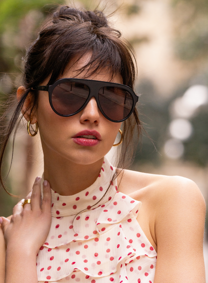 Model wearing Maxwell black acetate aviator sunglasses with brown-tinted lenses.