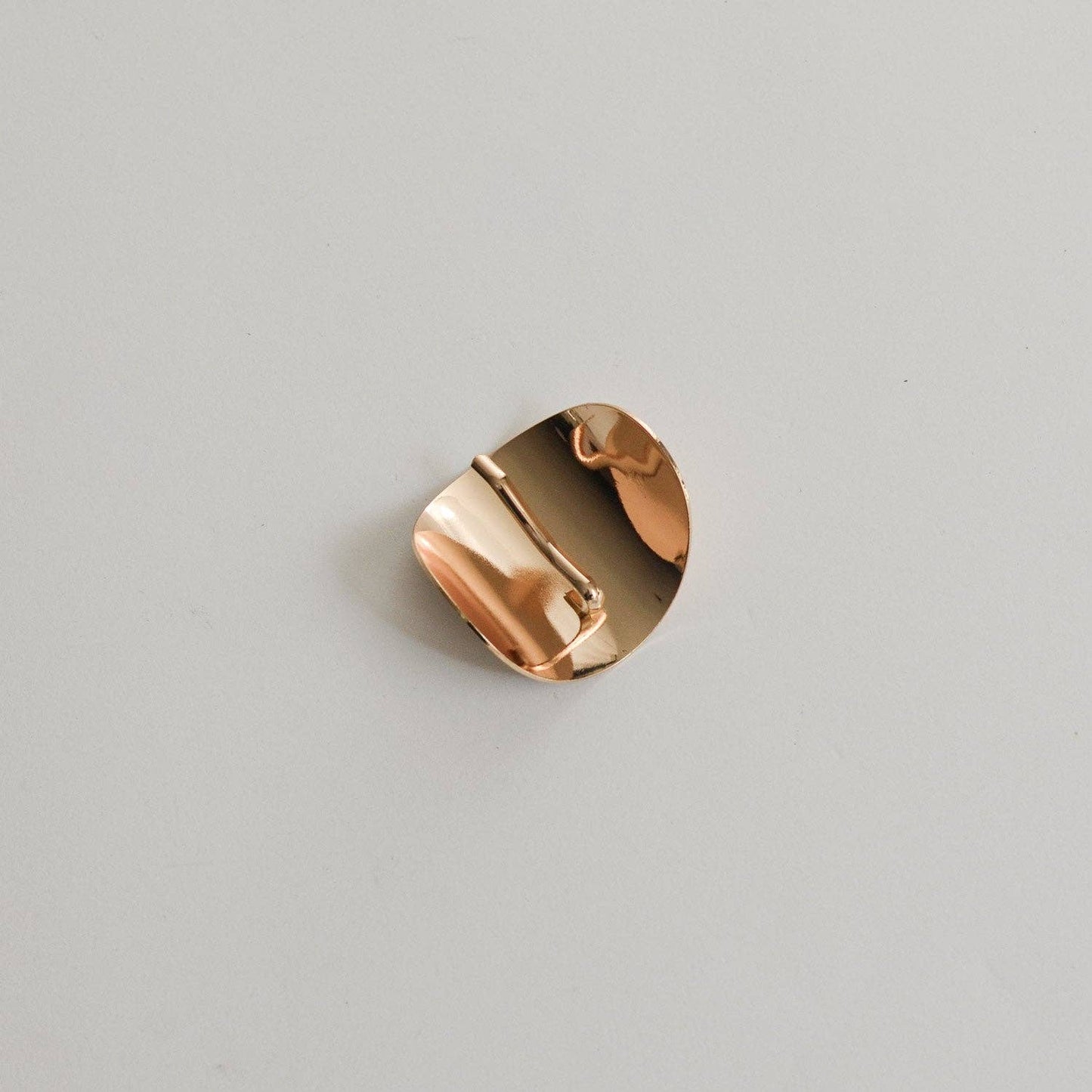 Back view of the gold oval ponytail cuff showing its curved interior and stick detail.