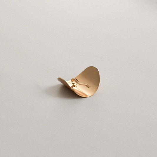 Side view of the gold oval ponytail cuff showing the built-in securing stick.