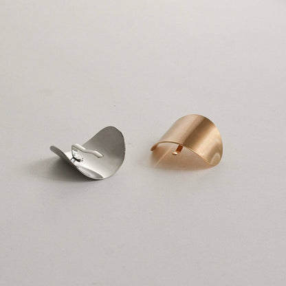 Gold and silver oval metal ponytail cuff sticks shown together on a neutral background.