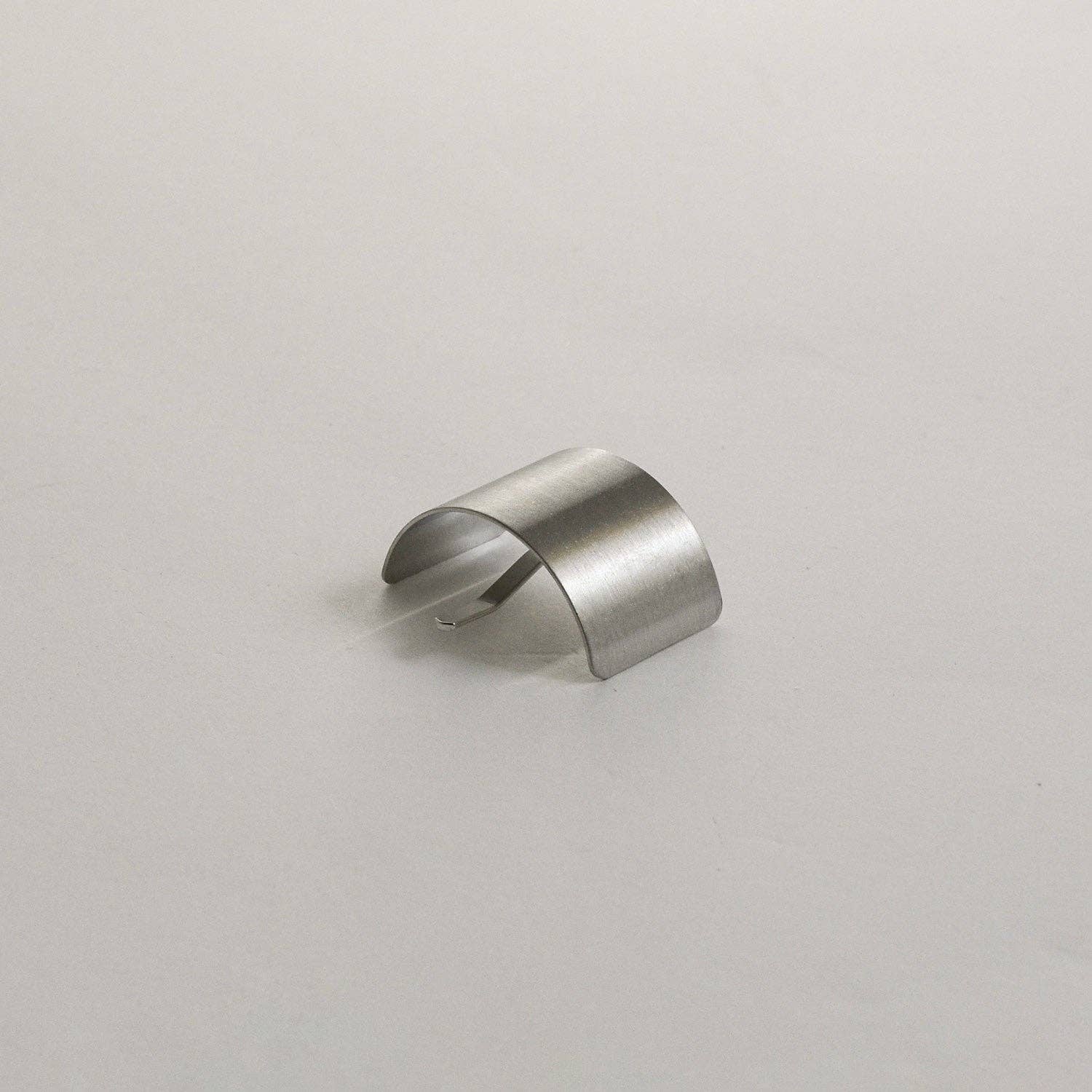 Curved profile view of the silver rectangular metal ponytail cuff stick on a neutral background.