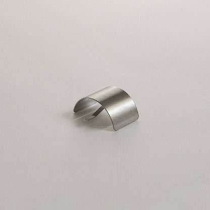 Curved profile view of the silver rectangular metal ponytail cuff stick on a neutral background.