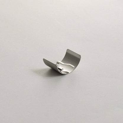 Side-angle view of the silver rectangular metal ponytail cuff stick showing its curved shape and built-in stick.