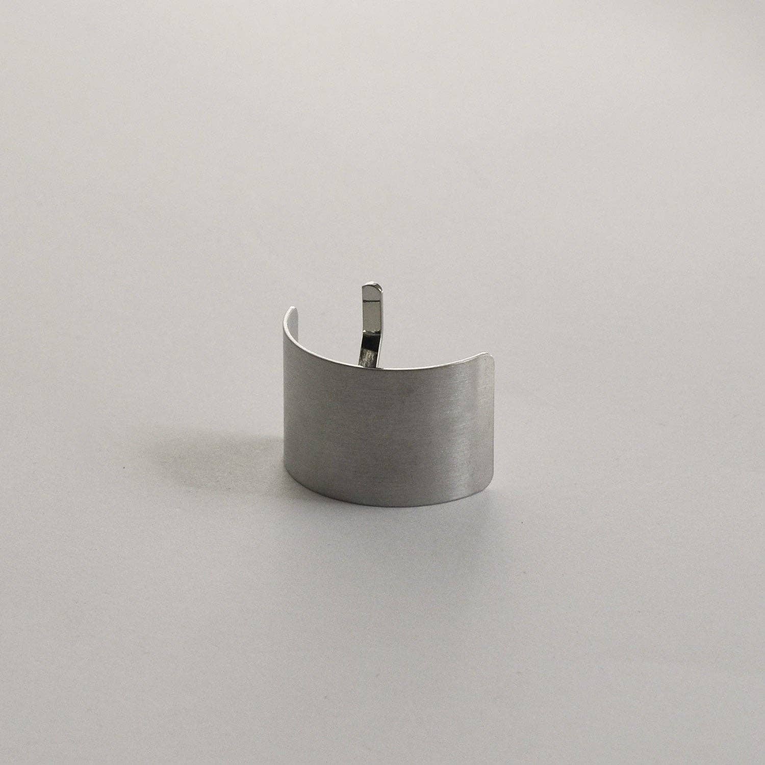 Upright view of the silver rectangular metal ponytail cuff stick highlighting its brushed metal finish.