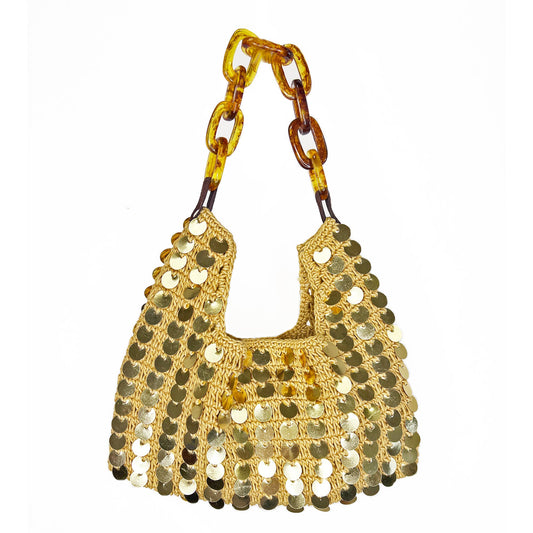 Handwoven cotton shoulder bag featuring allover gold sequin disc embellishments, a natural woven body, tortoiseshell-style acrylic chain handle, magnetic clasp closure, and lined interior.