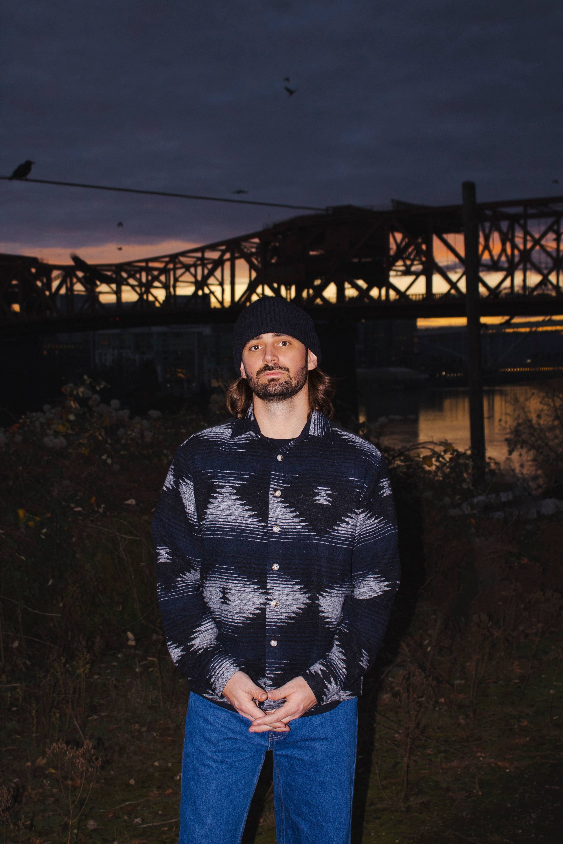 Front portrait of a model wearing the black and blue Moab Mid-Weight Button Down with bold Aztec-inspired patterning.