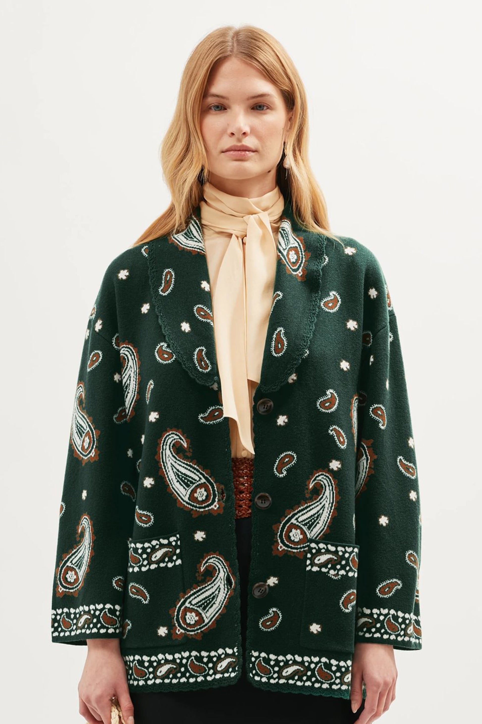 Front view of the Morla Cardigan in green featuring an intricate paisley print, V-neckline, single-button closure, and integrated patch pockets with contrasting trim details.