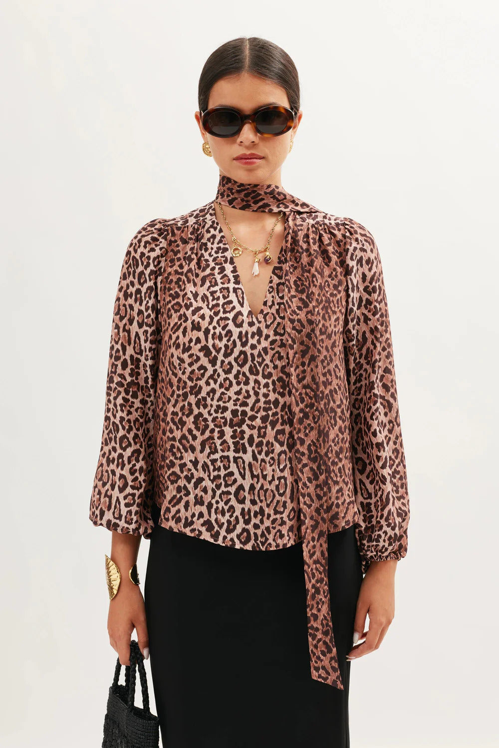 Portrait view of the Moss leopard print silk blouse featuring a relaxed silhouette and scarf tie detail