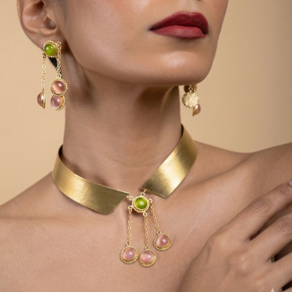 Cropped view of a model wearing the adjustable gold collar necklace and matching gemstone earrings.