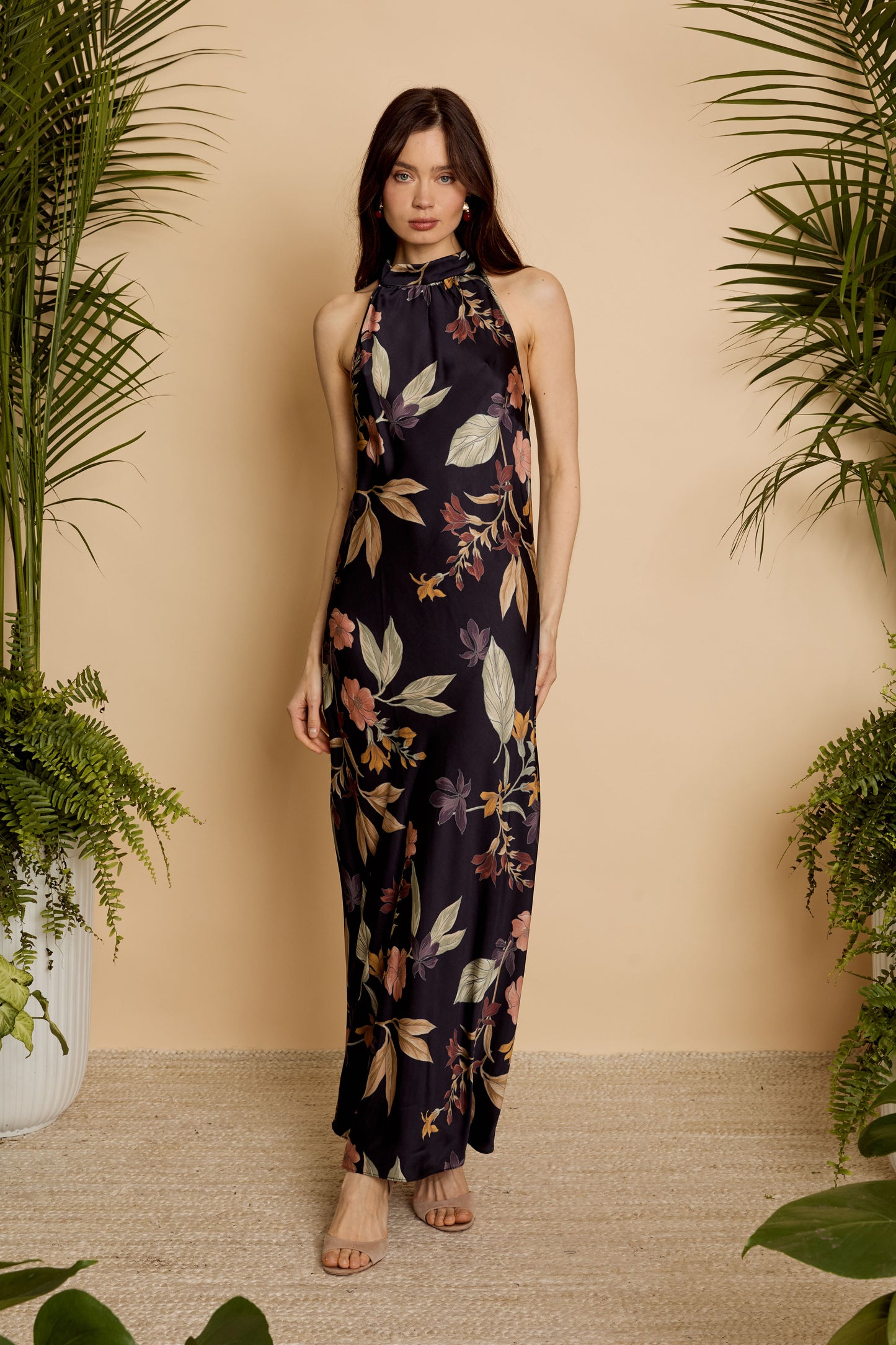 Front full-length view of model wearing the Naf Dress in Sundown Floral, a sleeveless floral maxi dress with a high neckline and fluid silhouette