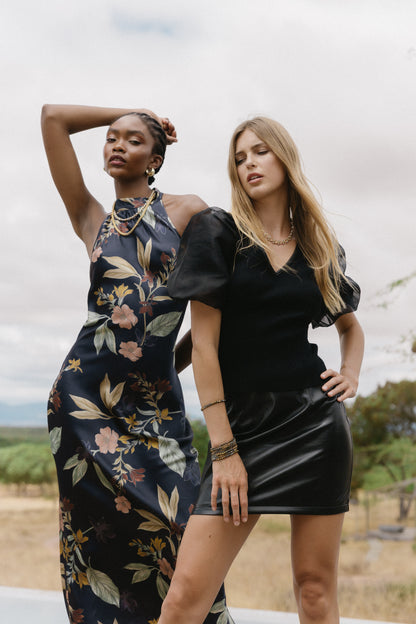 Close-up lifestyle image of model wearing the Naf Dress in Sundown Floral, highlighting the floral print and sleek silhouette
