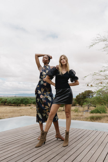 Model wearing the Naf Dress in Sundown Floral in an outdoor lifestyle image alongside another model