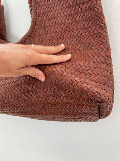 Close-up of the Narmada Brown Bag base highlighting the woven leather texture, structured corners, and handcrafted construction.