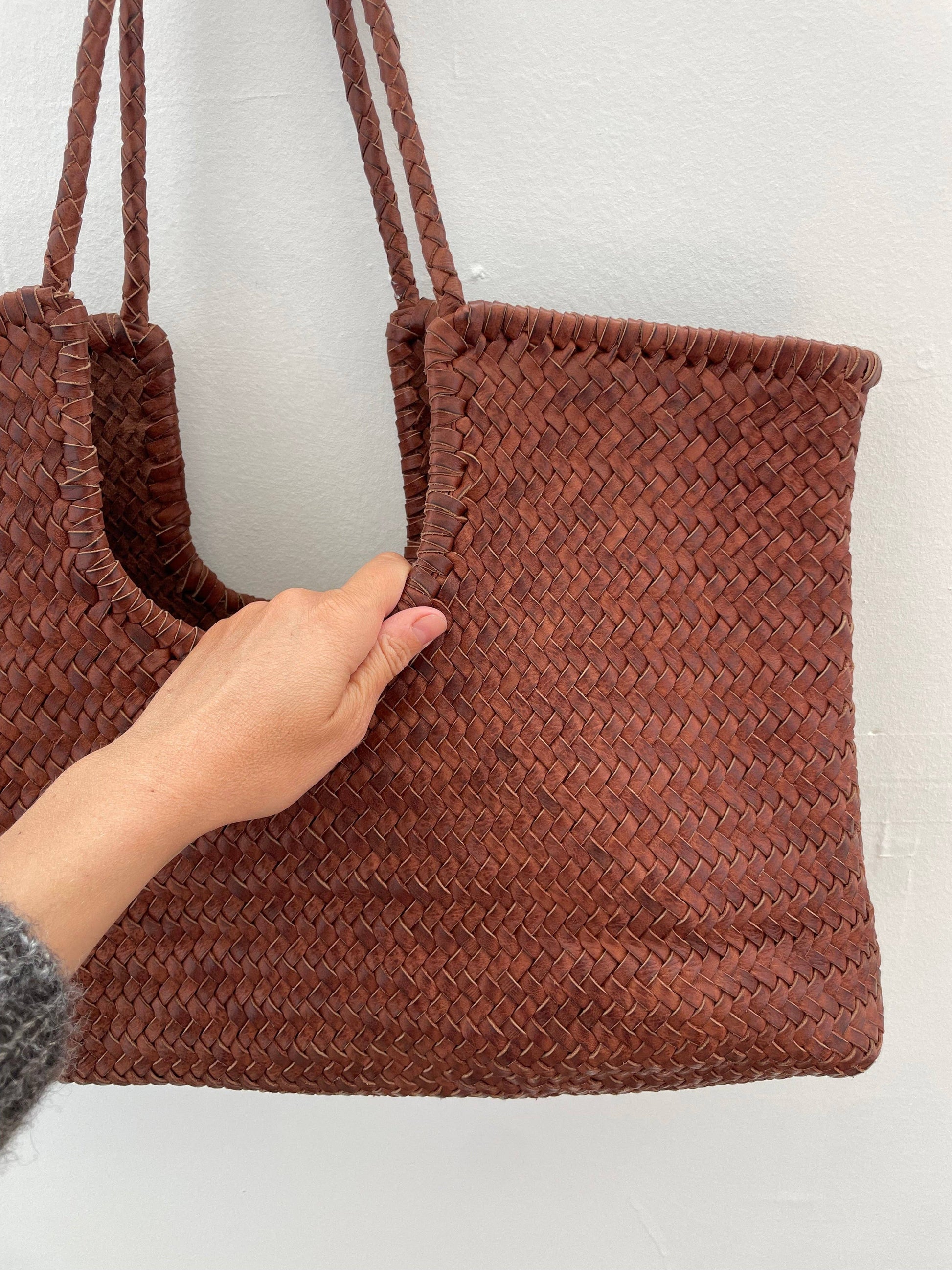 Front view detail of the Narmada Brown Bag highlighting the intricate woven leather pattern and spacious tote silhouette.