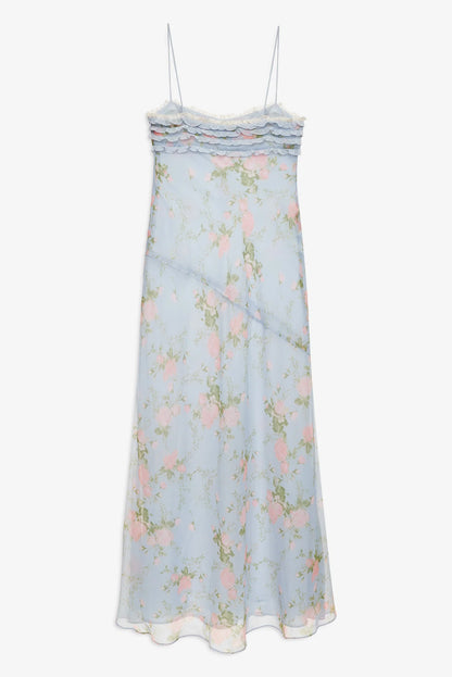 Back view of the Natalie Maxi Dress in dusty blue floral print with slim spaghetti straps, ruffle detailing, and flowing maxi skirt.