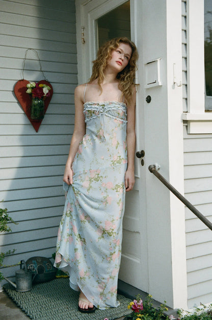Full-length editorial image of model wearing the Natalie Maxi Dress with pastel floral print and graceful flowing silhouette.