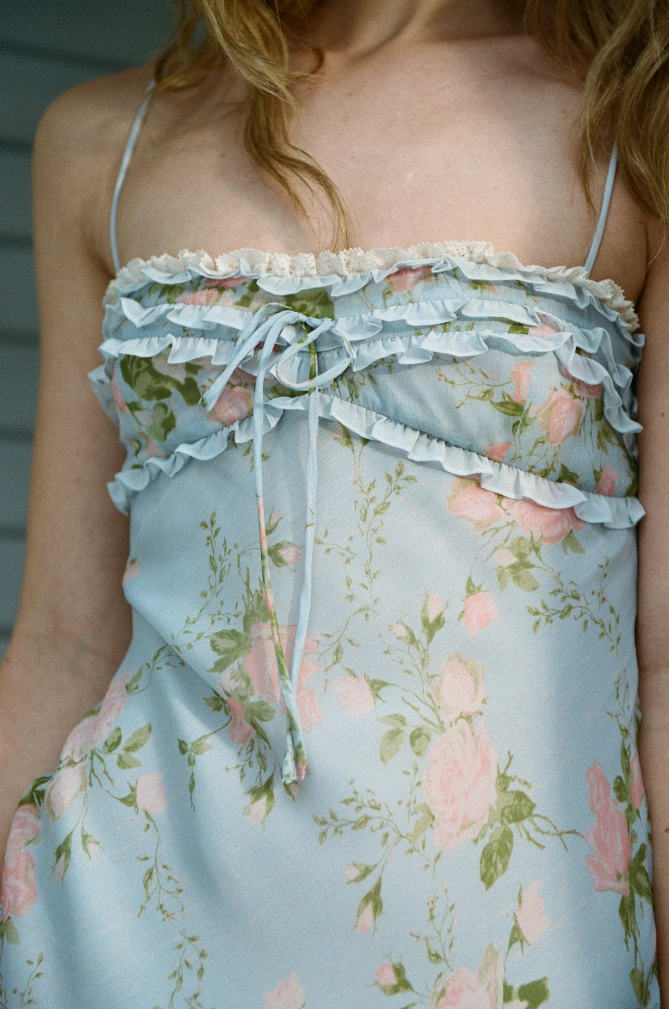 Detailed close-up of the Natalie Maxi Dress bodice featuring layered ruffles, lace trim, floral print, and front bow tie detail.