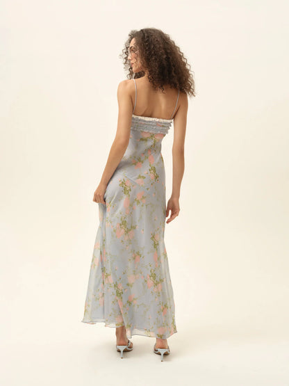 Back studio view of model wearing the Natalie Maxi Dress with slim straps, floral print, and elegant flowing skirt.