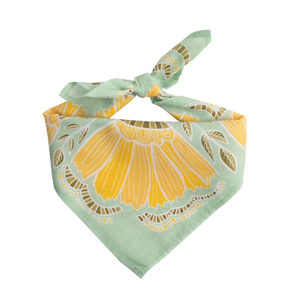 No. 044 Hazel Bandana folded and tied to display its light green, yellow, and olive botanical pattern.