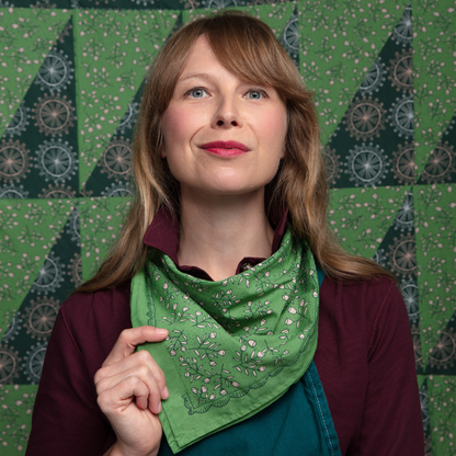 Woman wearing the Kelly green Posey Bandana folded and tied around her neck.