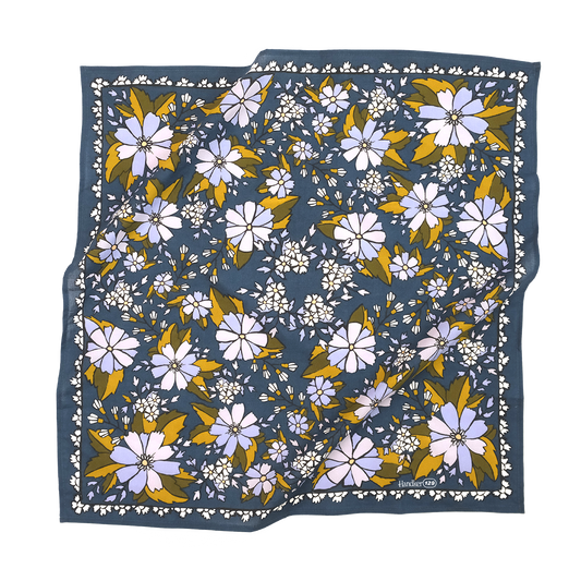 No. 129 Chicory Bandana laid flat, featuring lilac and purple flowers with muted green and golden leaves on a dark blue background.