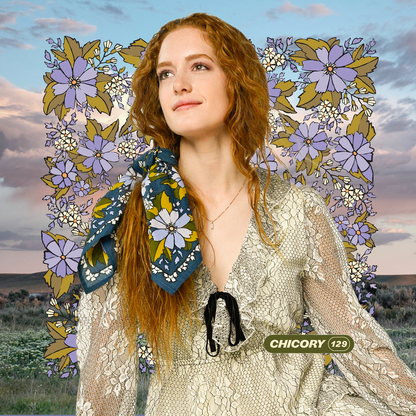 Woman wearing the No. 129 Chicory Bandana tied around her neck with a light embroidered blouse.