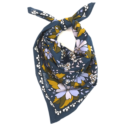 No. 129 Chicory Bandana folded and tied to show its dark blue floral print and patterned border.