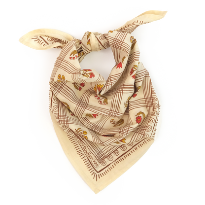 Creamy yellow No. 130 Laura Bandana with brown grid lines, rust floral details, and olive accents shown knotted on a white background.