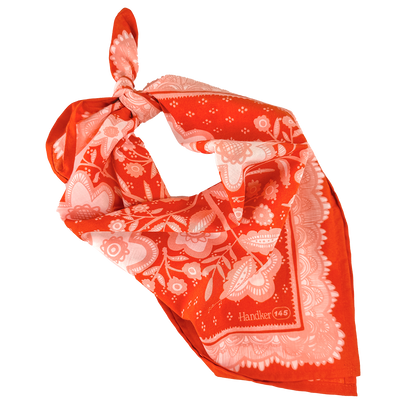 Red-orange and pink floral Lacey Bandana folded into a triangle and tied at the top.