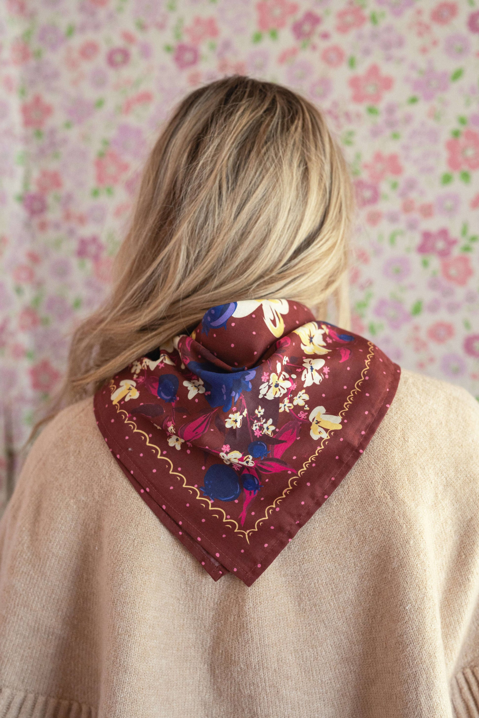 Front view of a woman wearing the No. 150 Meg Bandana tied at the neck with a neutral cardigan.