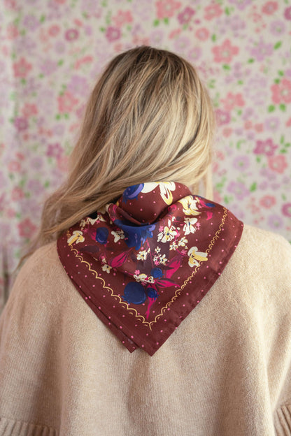 Front view of a woman wearing the No. 150 Meg Bandana tied at the neck with a neutral cardigan.