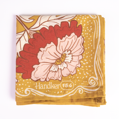 Close-up of the Ruthie Bandana showing its pink floral motif with ochre gold, brown, and cream details.