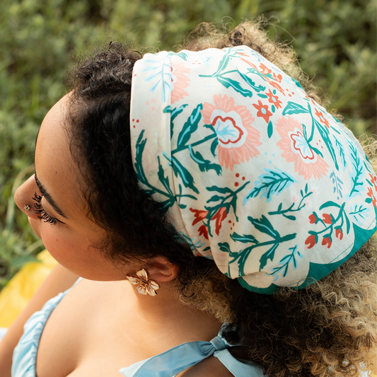 oman wearing the No. 156 Willa Bandana tied over her curly hair as a headscarf.