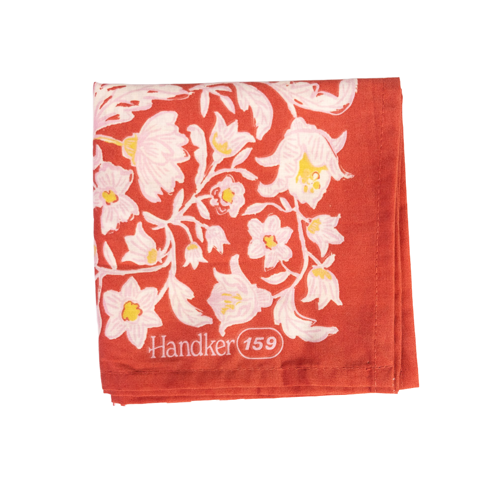 Folded No. 159 Delphine Bandana showing its poppy red, ochre gold, and cream botanical print.