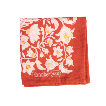 Folded No. 159 Delphine Bandana showing its poppy red, ochre gold, and cream botanical print.