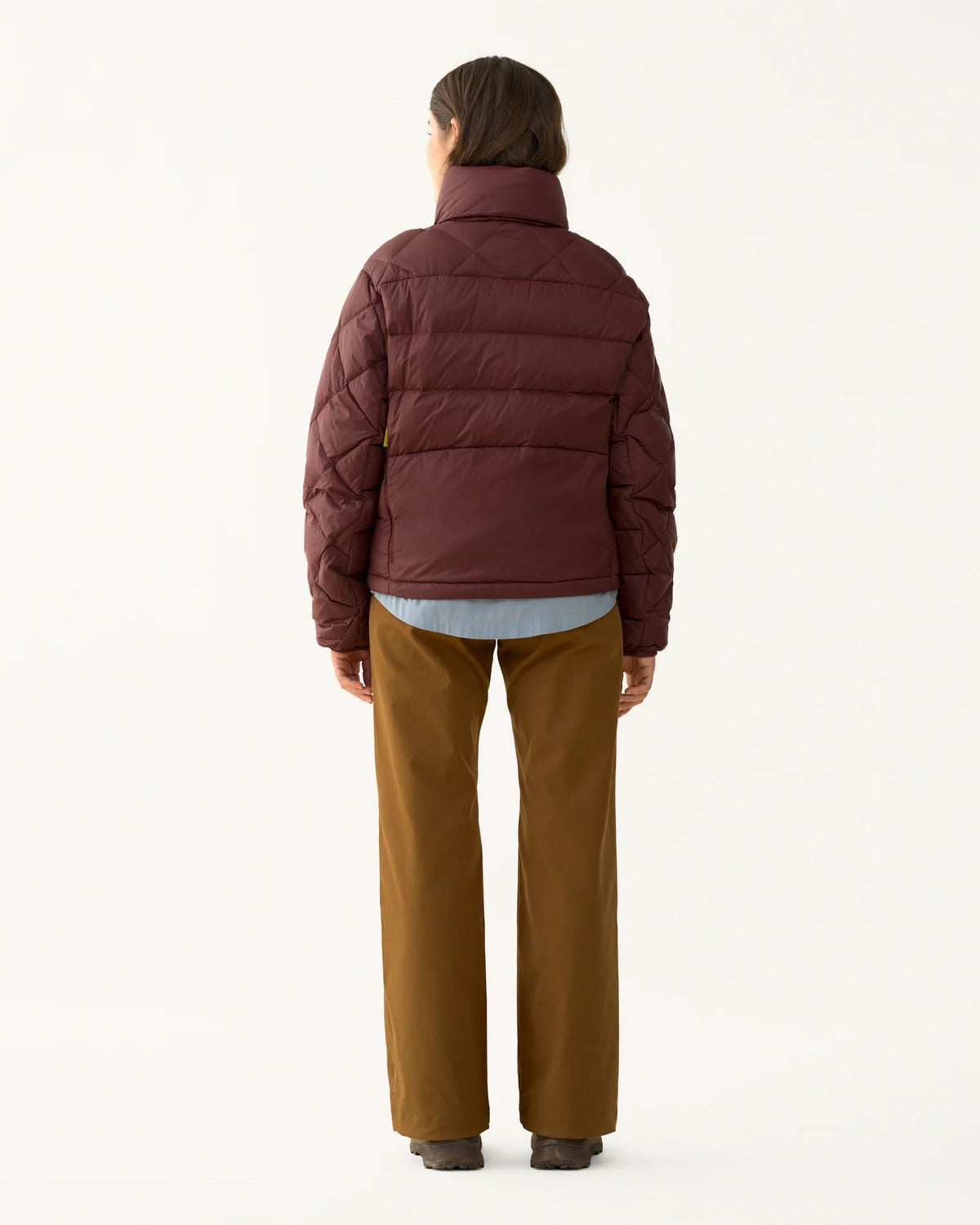 Woman wearing the Packable Down Puffer, showing the quilted back and cropped silhouette