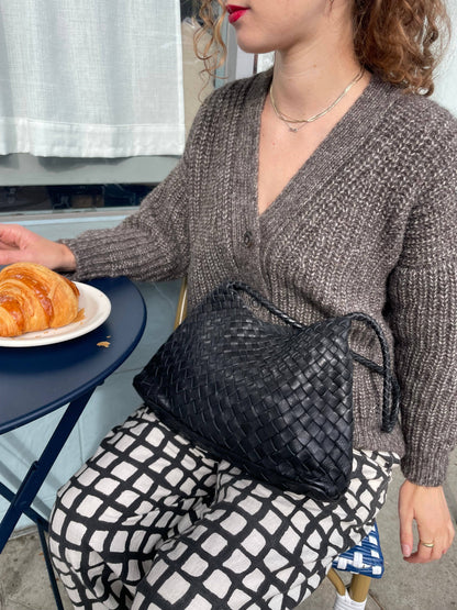 Palar Black Bag styled over the shoulder with a neutral cardigan at an outdoor café