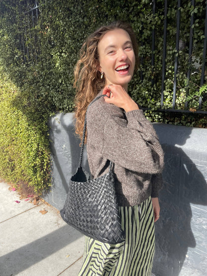 Model carrying the Palar Black Bag over the shoulder outdoors
