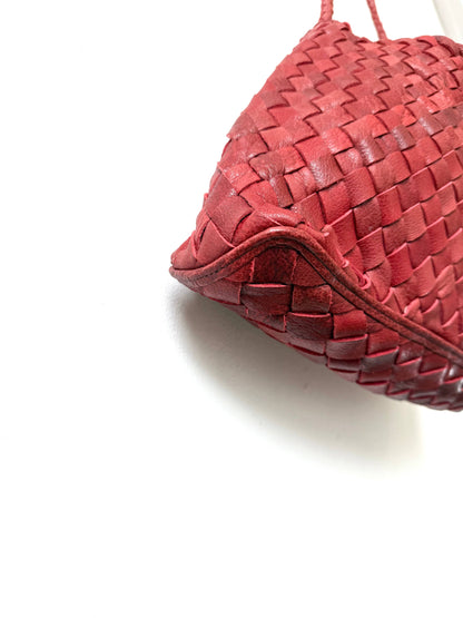 Close-up of the handwoven leather and curved base of the Palar Red Bag