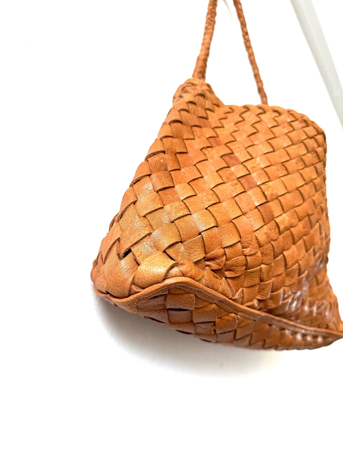 Angled view of the Palar Tan Bag showing its handwoven leather texture and softly structured shape