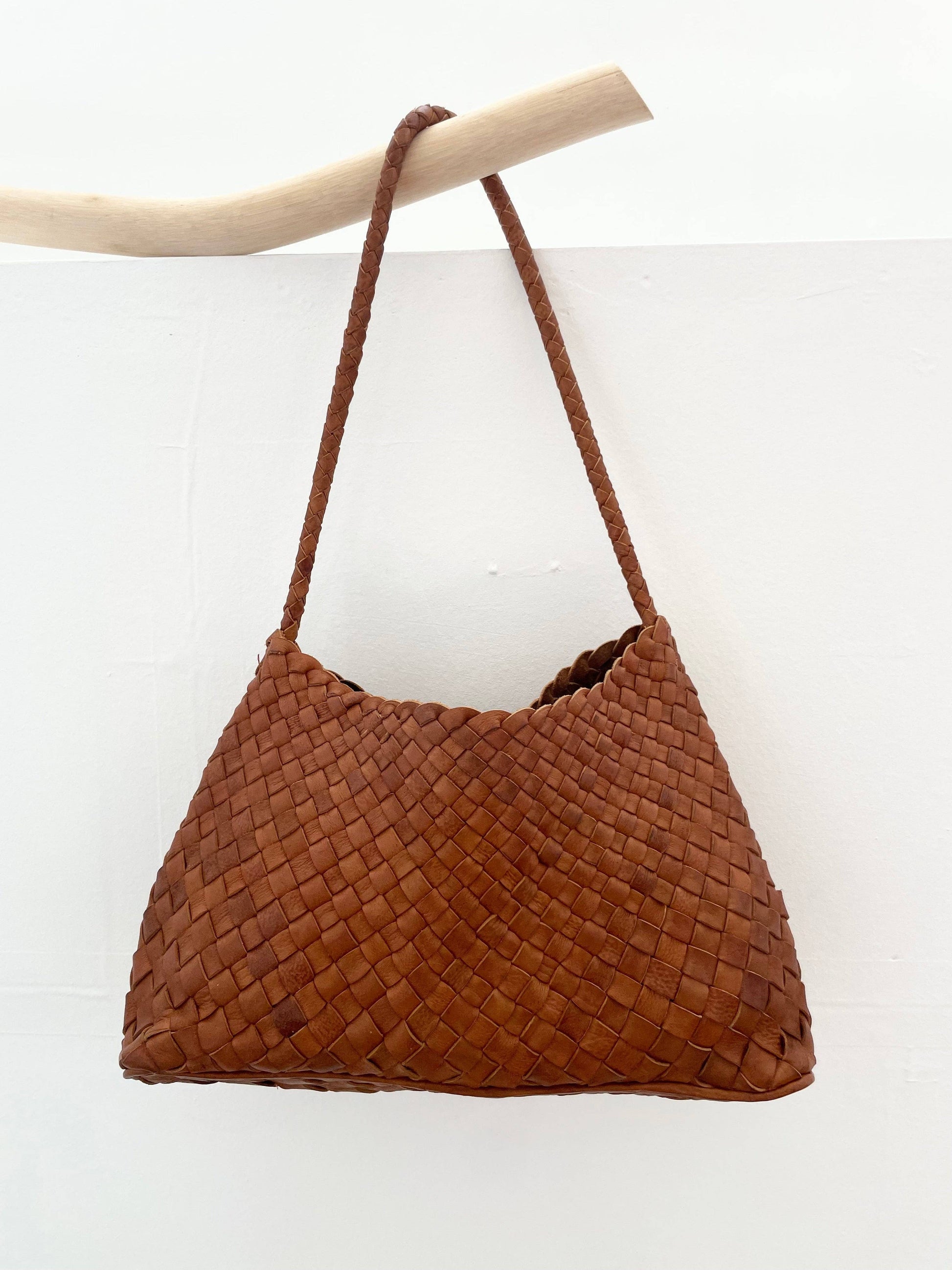 Palar Tan Bag hanging from a branch against a white background
