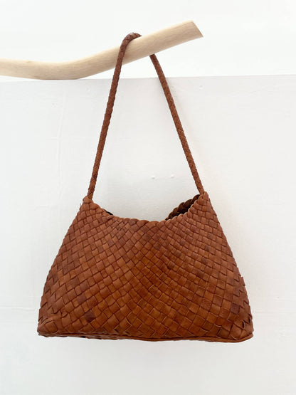 Palar Tan Bag hanging from a branch against a white background