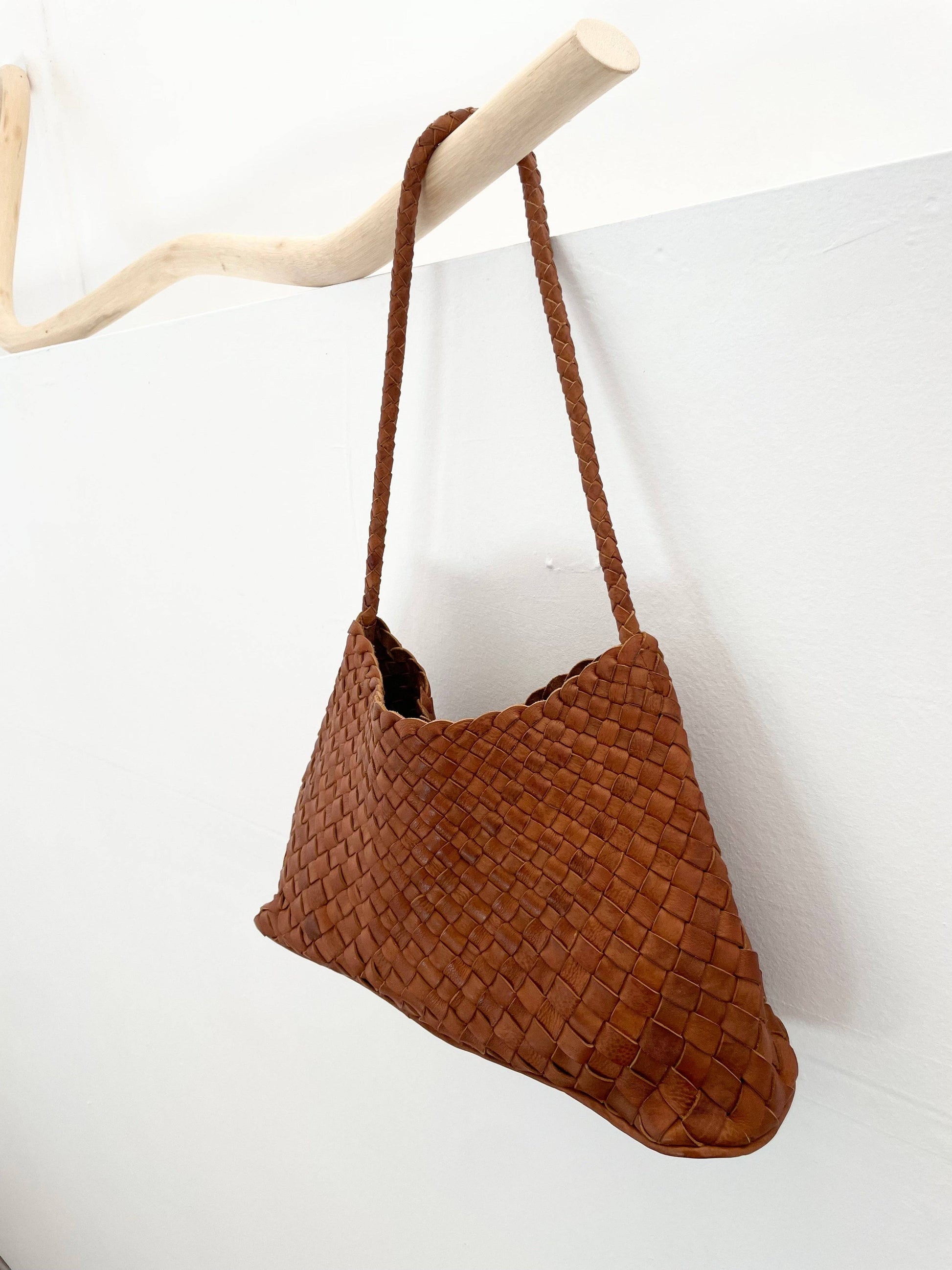 Side view of the Palar Tan Bag hanging against a white background
