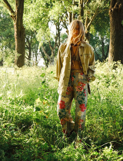 Model wearing Maison Hotel Pepe Pant in Hulton Soul Noir print featuring oversized florals layered over washed black stripes in a wide-leg cotton silhouette outdoors.