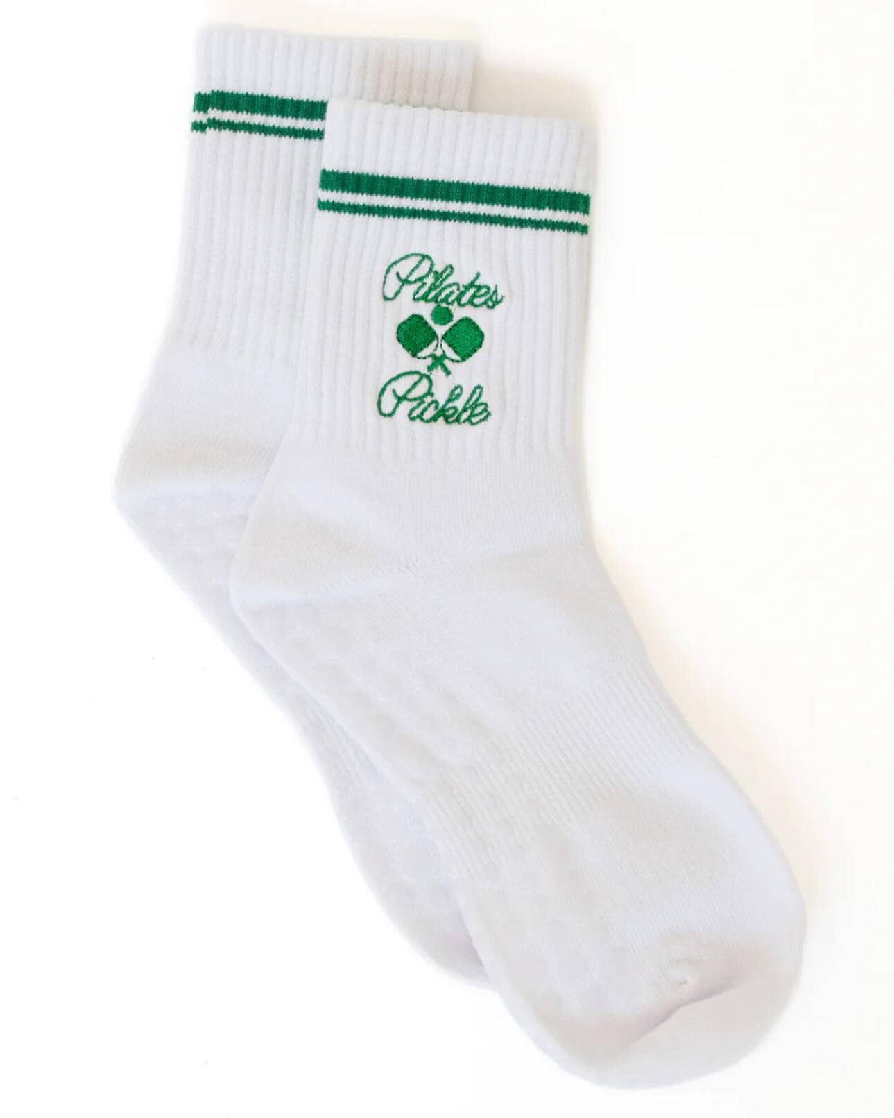 Pair of white Pilates Pickle grip socks with green embroidered pickleball design, ribbed crew length, and non-slip grip dots on the sole.