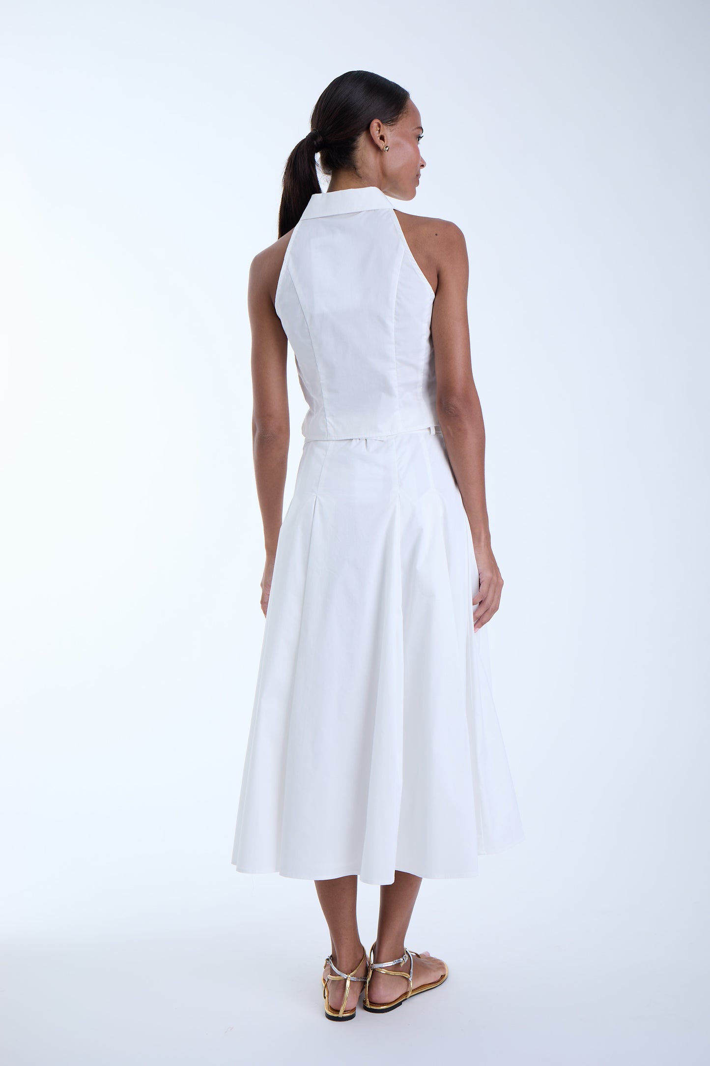 Back view of the Poppy Midi Skirt in white showing the high-rise waist, clean back paneling, and softly flared midi-length silhouette.