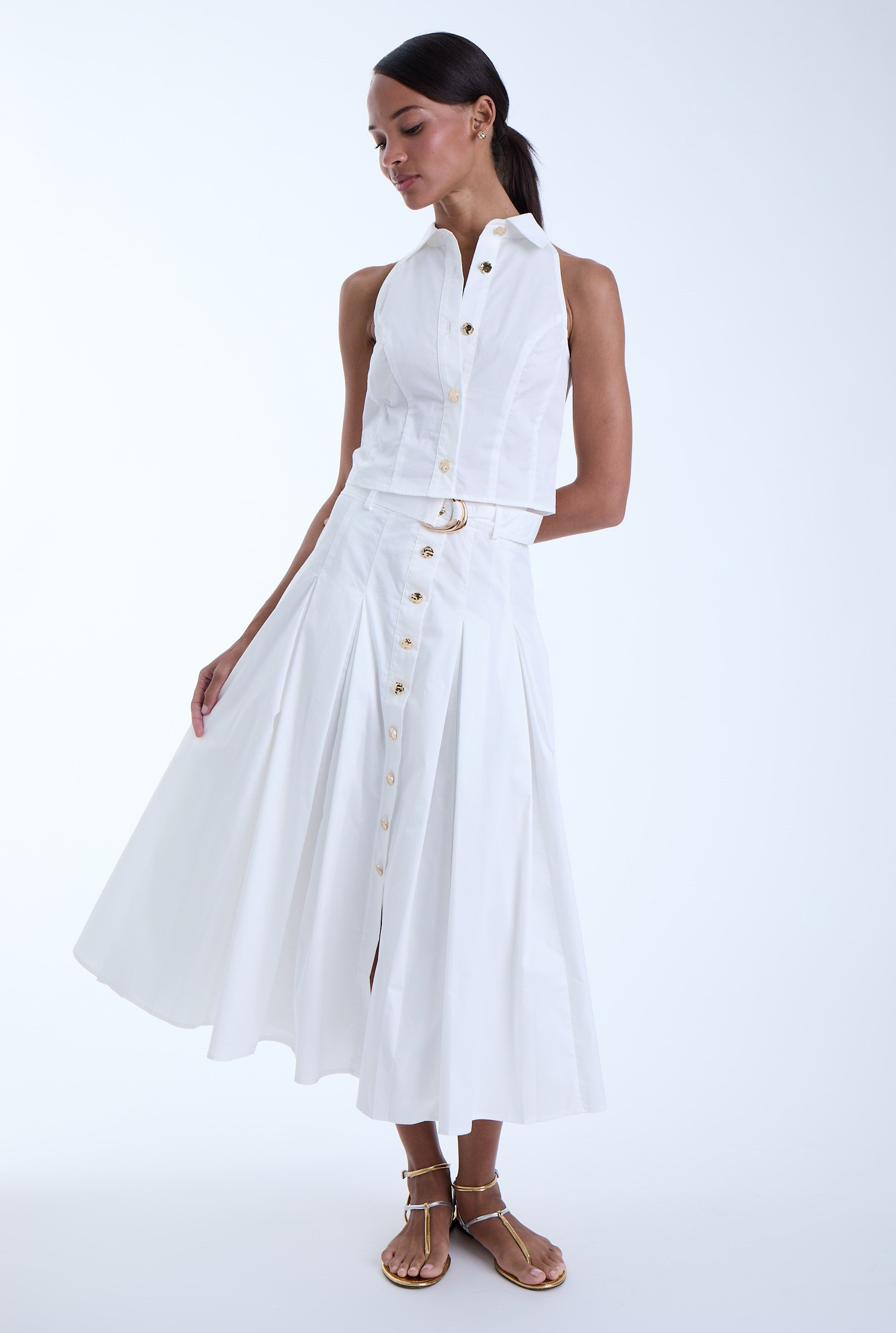 Front view of the Poppy Midi Skirt in white featuring a high-rise waist, button-front design, self-belt with gold-tone buckle, and a full midi-length silhouette.