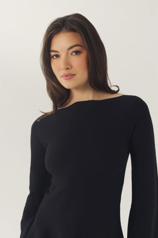 Close-up of the black Prescott dress showing the wide boat neckline and smooth knit fabric.