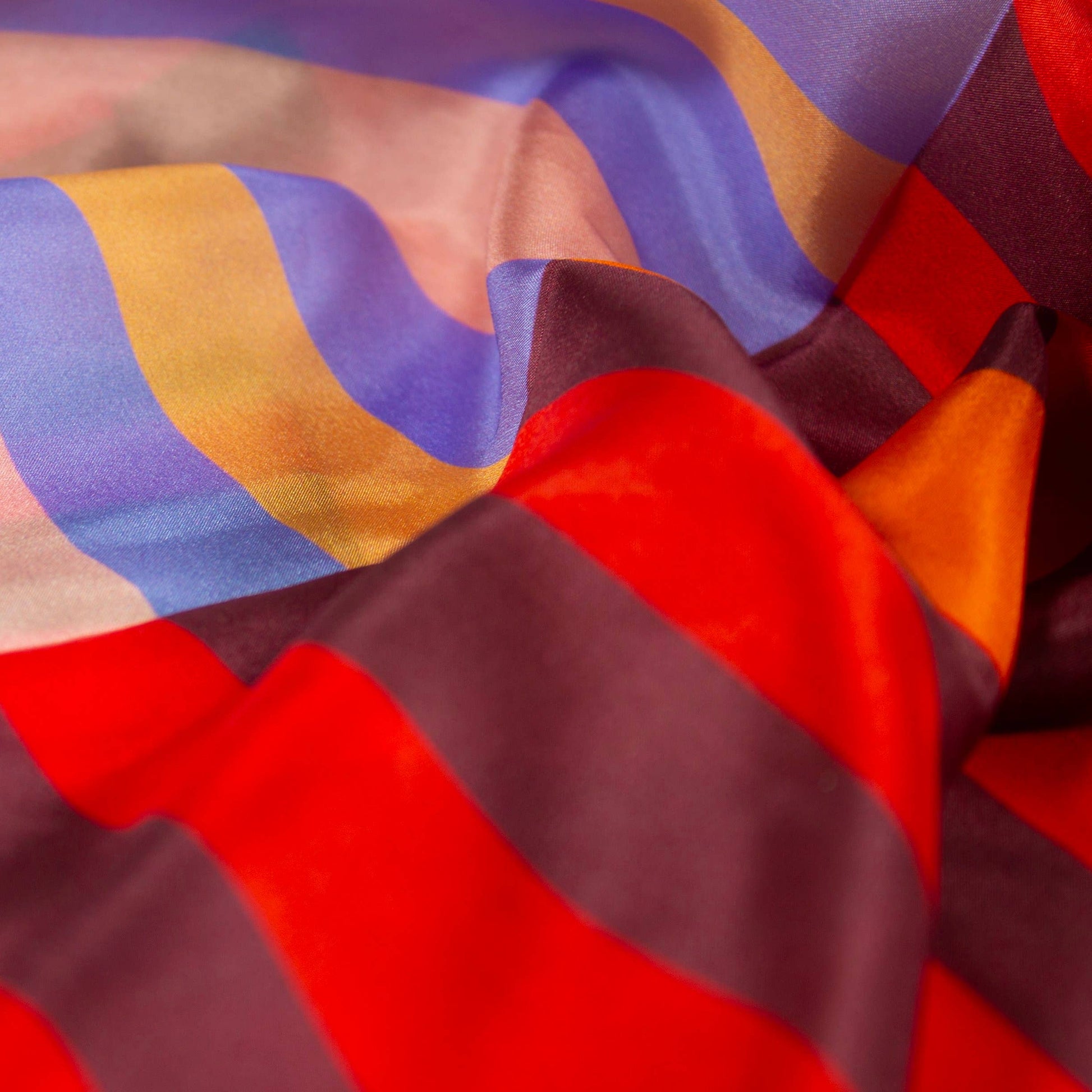 Close-up of Red Colorblock silk scarf fabric showing soft drape, luminous finish, and bold red and pastel colorblocking.