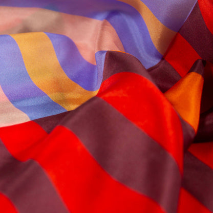 Close-up of Red Colorblock silk scarf fabric showing soft drape, luminous finish, and bold red and pastel colorblocking.